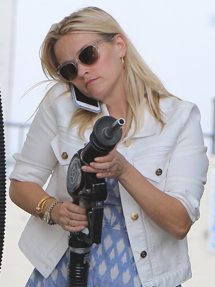 Reese Witherspoon pumps gas with her blonde hair worn down