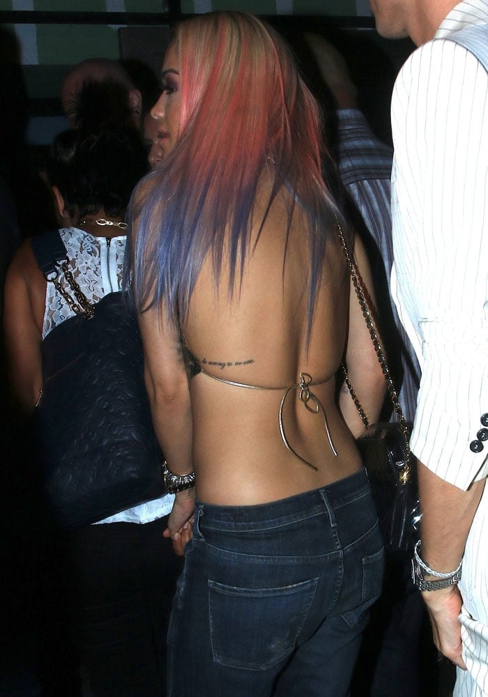 Rita Ora shows off a ribcage tattoo and multicolored hair as she arrives at a Hollywood nightclub in a handkerchief top