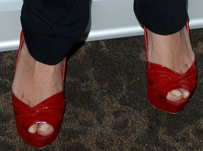 Salma Hayek complements her Saint Laurent outfit by showing off her toes in bright red patent platform heels