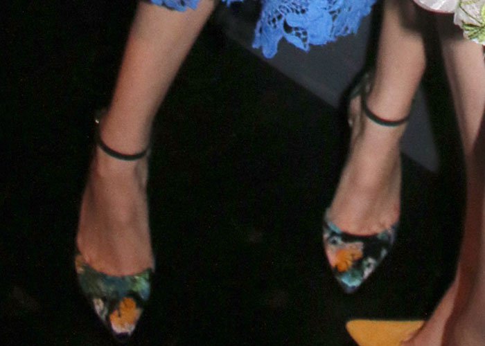 Bella Thorne wears a pair of floral-print satin pumps from Monique Lhuillier