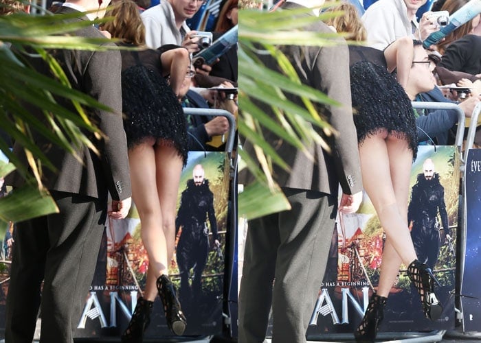 Cara Delevigne shows off a peek of her underwear and underbutt as she leans over a little too far during the "Pan" premiere