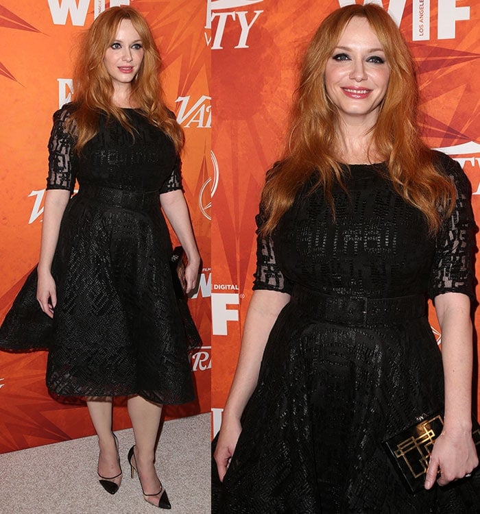 Christina Hendricks holds a Charlotte Olympia clutch and smiles for the cameras