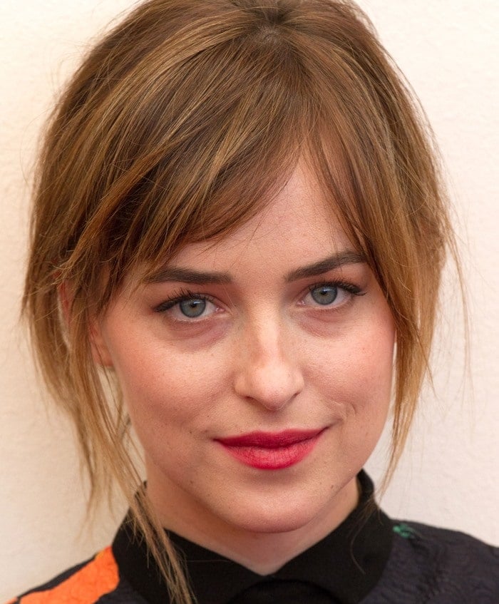 Dakota Johnson hiding her teeth at the 2015 Venice Film Festival photocall for "A Bigger Splash"