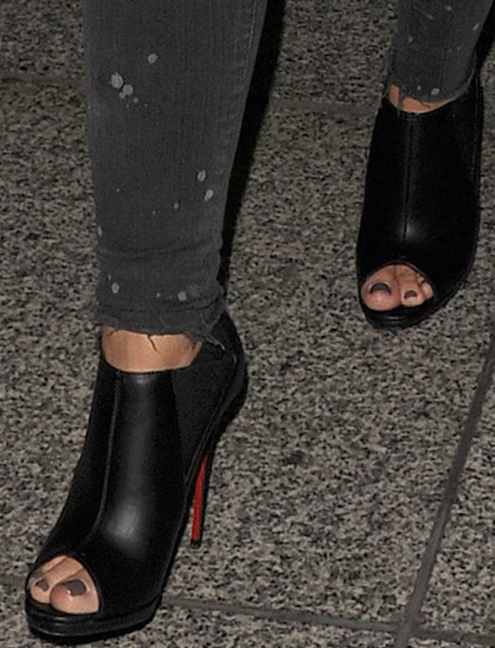 Demi Lovato shows off her Christian Louboutin peep-toe booties as she struts through Heathrow