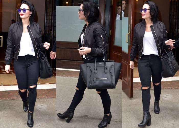 Demi Lovato wears a black jacket and TopShop jeans as she exits her New York hotel