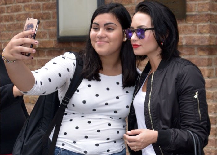 Demi Lovato poses for selfies with fans outside of her New York hotel