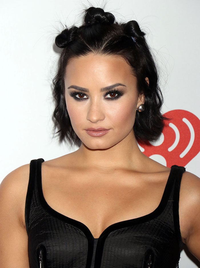 Demi Lovato shows off her ’90s punk hairstyle with three mini buns on top of her head at the 2015 iHeartRadio Music Festival