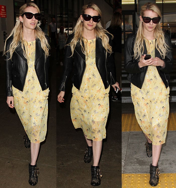 Emma Roberts holds her phone and hides her eyes behind oversized sunglasses as she strolls through a terminal at LAX