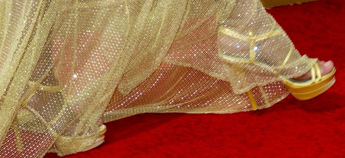 Heidi Klum's gold Versace sandals almost get caught in the netting of her matching Versace gown