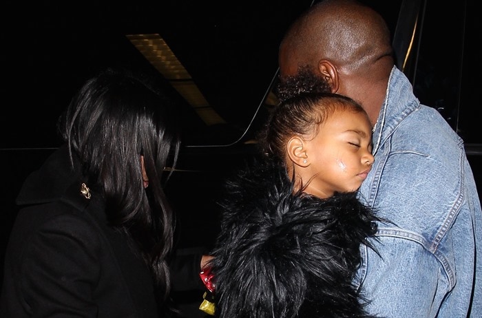 North West sleeps on the shoulder of Kanye West as her family enters the LAX airport