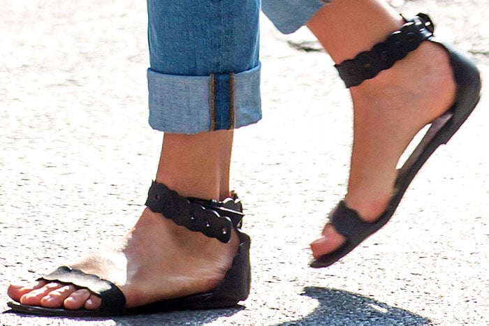 Karlie Kloss catches a cab in a pair of scallop-edged black flat sandals