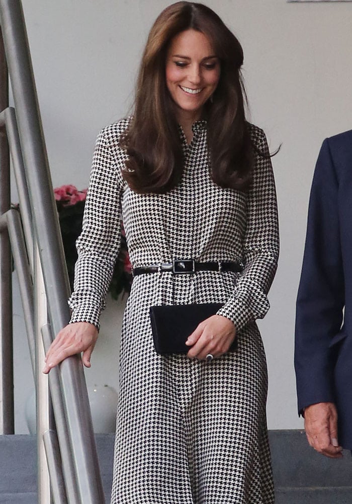 Kate Middleton wears her hair down and shows off her wedding ring and her clutch