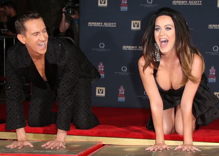 Jeremy Scott and Katy Perry pose while participating in a cement handprint ceremony on the red carpet