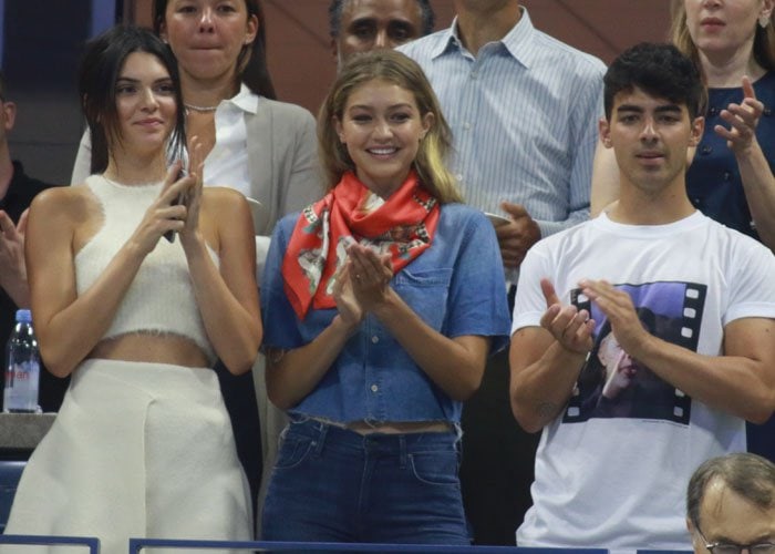 Kendall Jenner, Gigi Hadid and Joe Jonas applaud during a tennis match between the Williams sisters