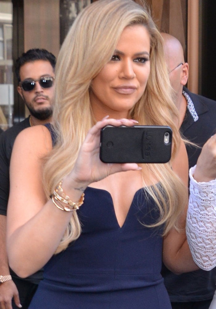 Khloe Kardashian holds her cellphone while leaving Trump Hotel Soho