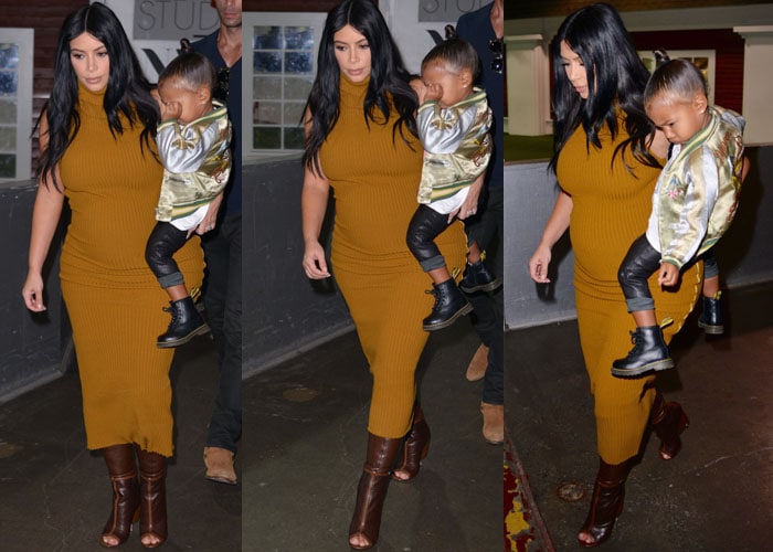 Kim Kardashian holds North West in one harm as she avoids looking at the paparazzi