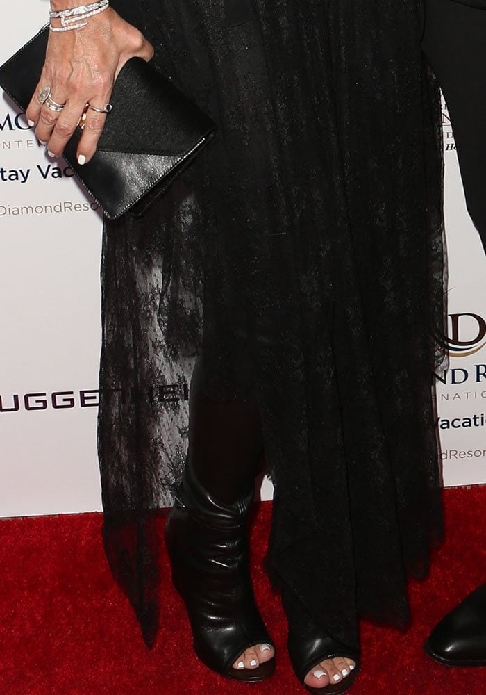 Kris Jenner wore a black top and tights underneath a sheer lace plunging dress and Givenchy Narlia boots in black