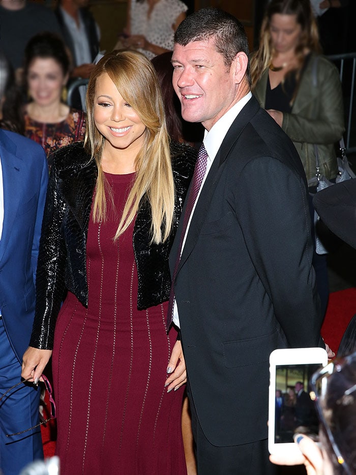 A fan captures a photo of both Mariah Carey and James Packer on a smartphone