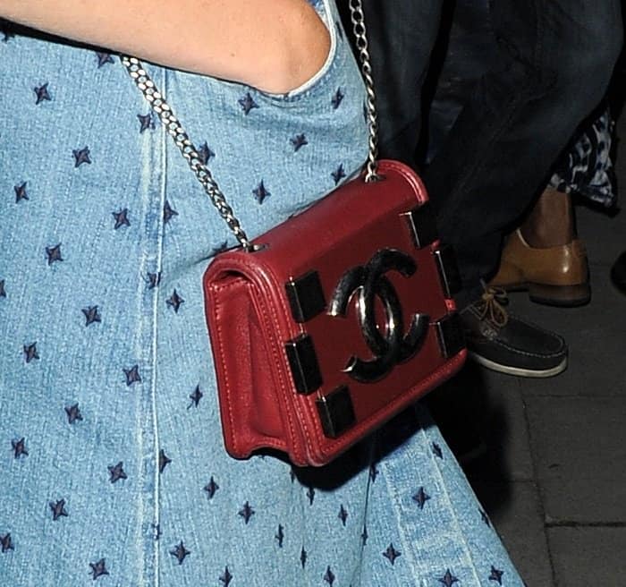 Poppy Delevingne totes a mini Chanel crossbody purse in deep red