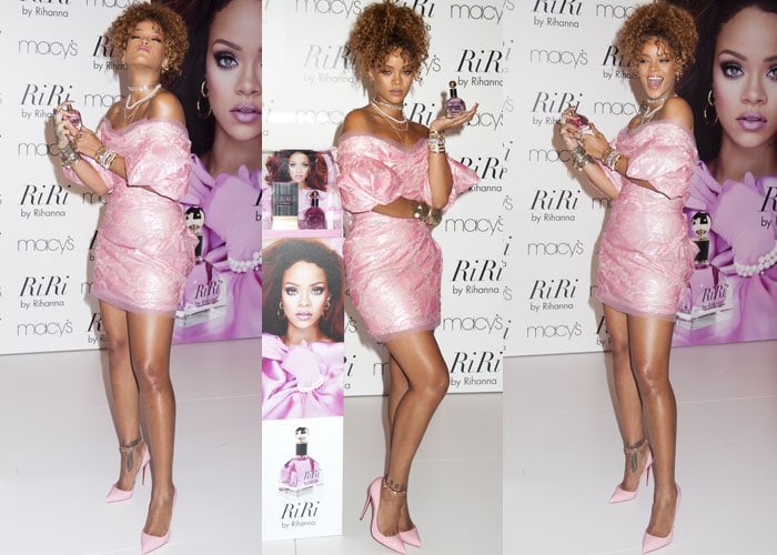 Rihanna poses with her latest fragrance while wearing a bright pink dress from Vivienne Westwood