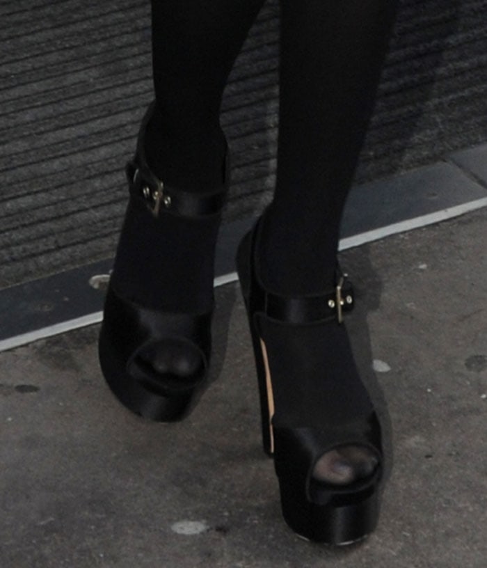 Selena Gomez wears a pair of platform Brian Atwood shoes on her stocking-covered feet