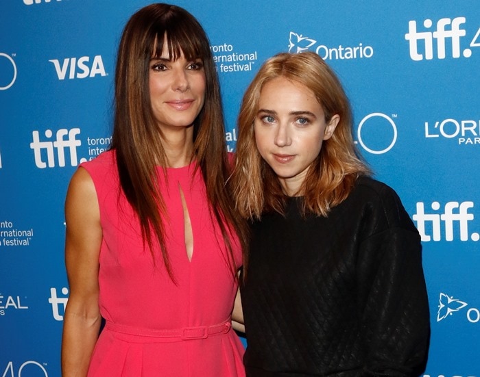 Sandra Bullock and Zoe Kazan pose in front of a branded backdrop at the Toronto International Film Festival