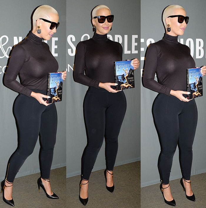 Amber Rose covers up in a turtleneck top but still shows off her curves in tight clothing