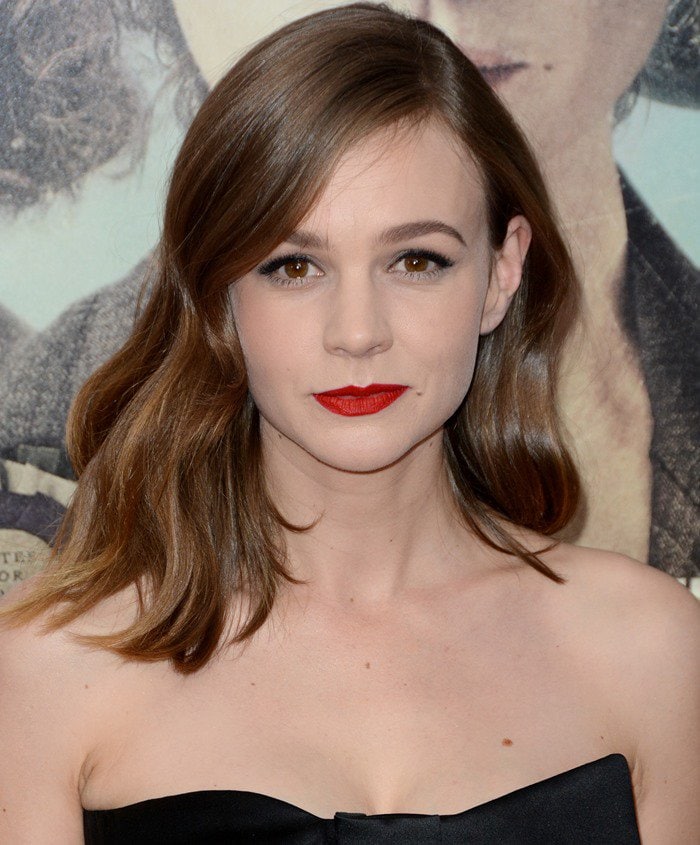 Carey Mulligan captivates in a strapless black dress, highlighting her porcelain complexion and bold red lipstick