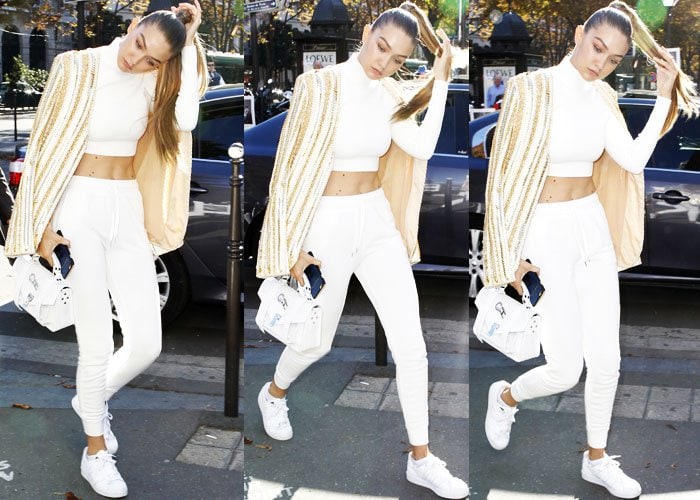 Gigi Hadid plays with her hair as she goes shopping in a Balmain and Adidas look