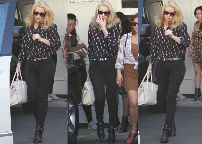 Iggy Azalea wears black pants and a lipstick-print blouse as she visits a Los Angeles cosmetic surgery clinic