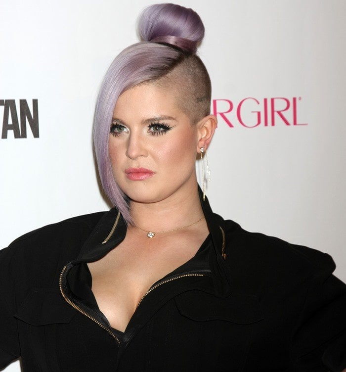 Kelly Osbourne rocks an edgy purple side-shaved top bun, exuding confidence and bold style