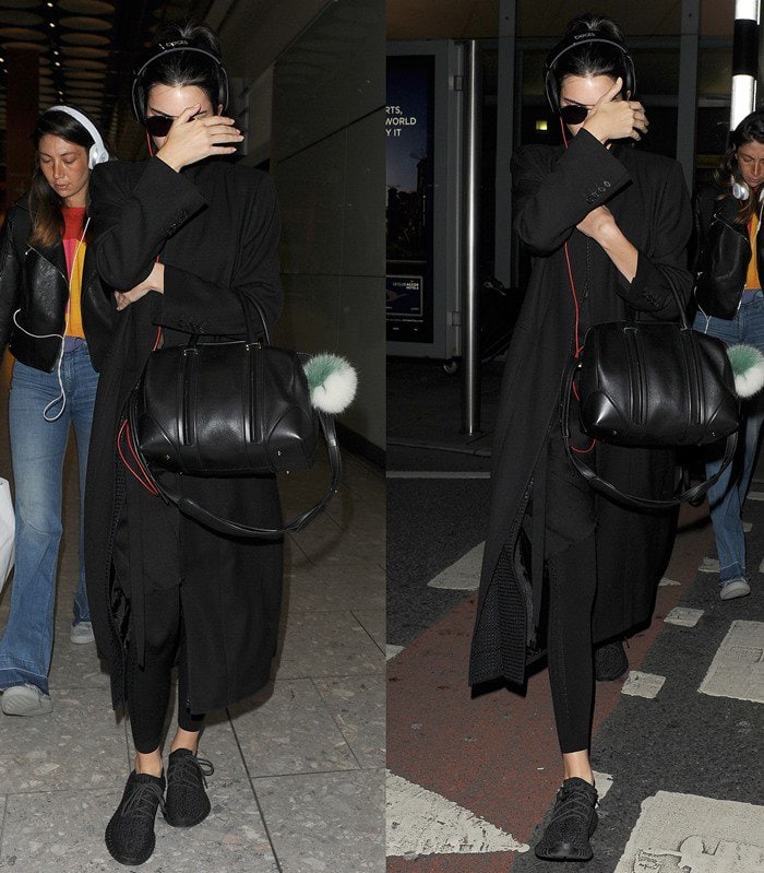 Kendall Jenner wears her hair up and keeps a pair of Beats headphones on her ears