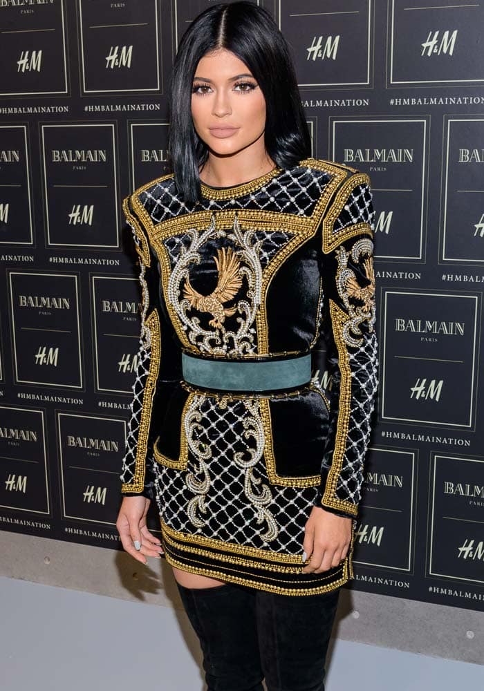 Kylie Jenner wears her dark hair with a center part at the H&M x Balmain collection launch