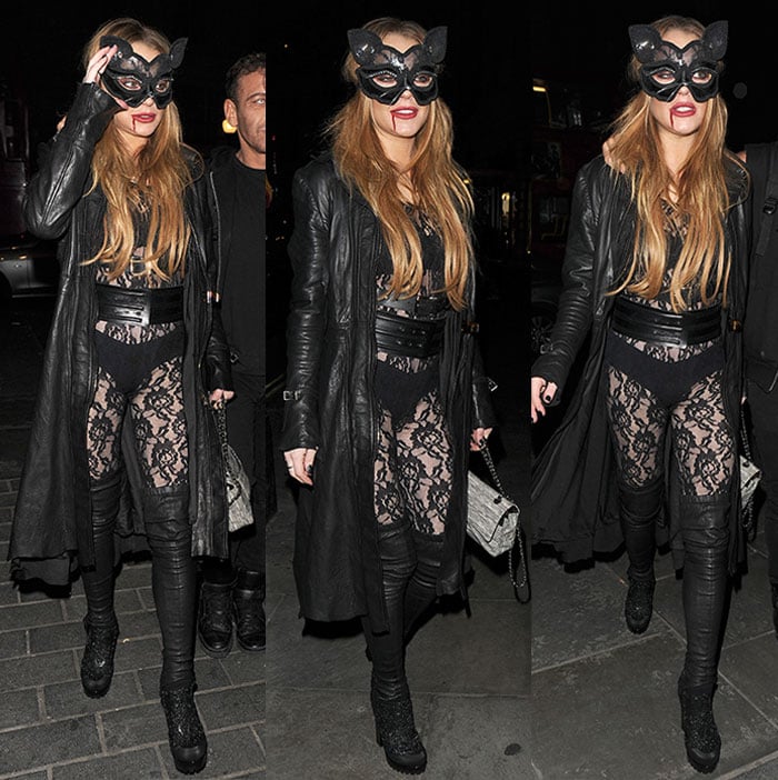 Lindsay Lohan adjusts her cat mask while attending a Halloween party in London