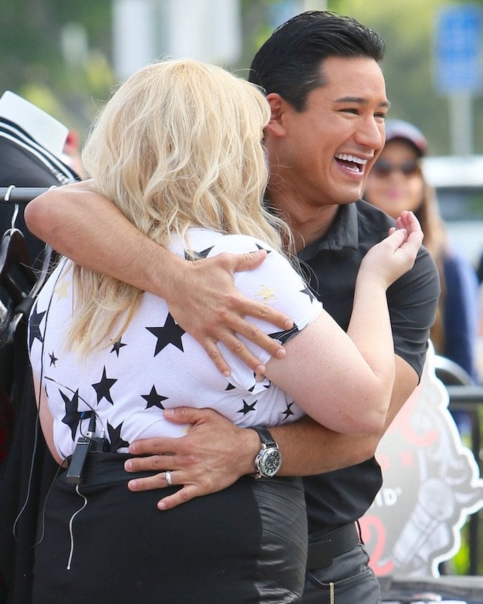 Rebel Wilson and Mario Lopez laugh around together on the "Extra TV" set