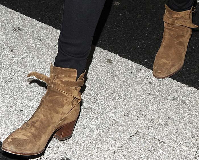 Rita Ora wears a pair of Saint Laurent boots on her feet as she strolls through a London airport