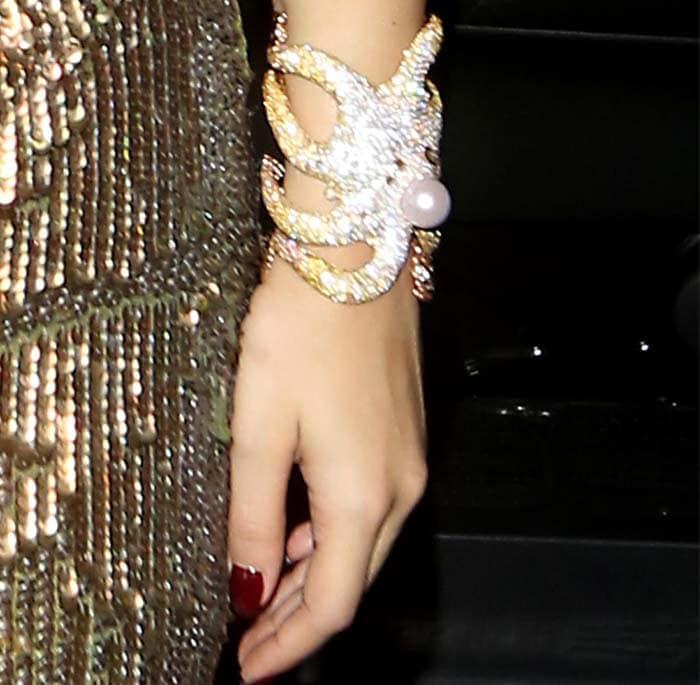 Rita Ora shows off a sparkling octopus-style wrist cuff during a London outing 