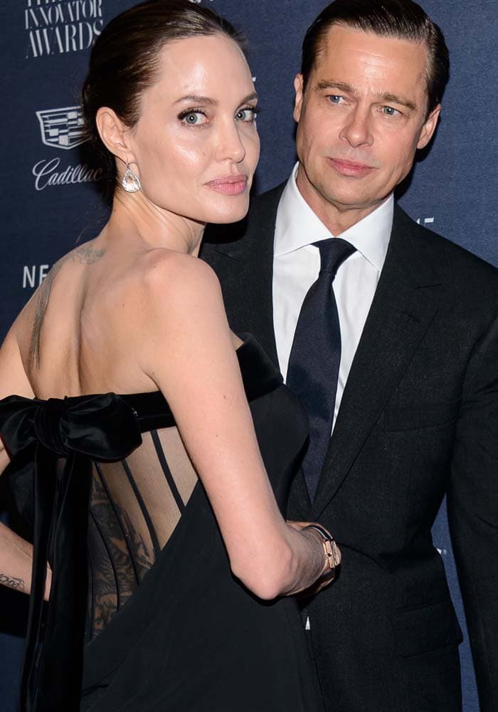 Angelina Jolie shows off her back tattoos as she faces husband Brad Pitt at the WSJ Magazine 2015 Innovator Awards