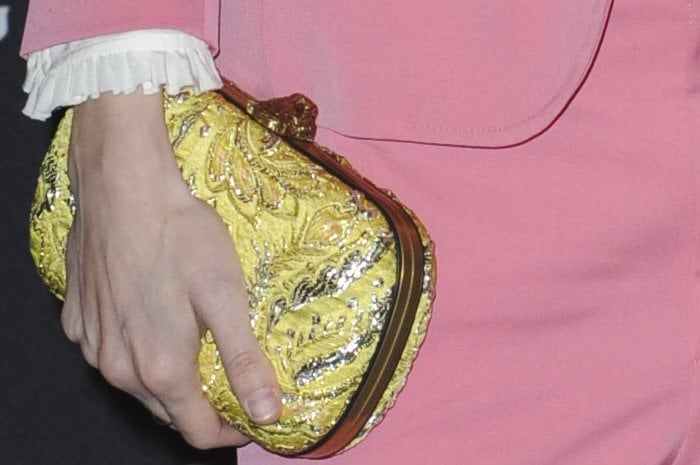 Brit Marling carries a yellow clutch in her unmanicured hands