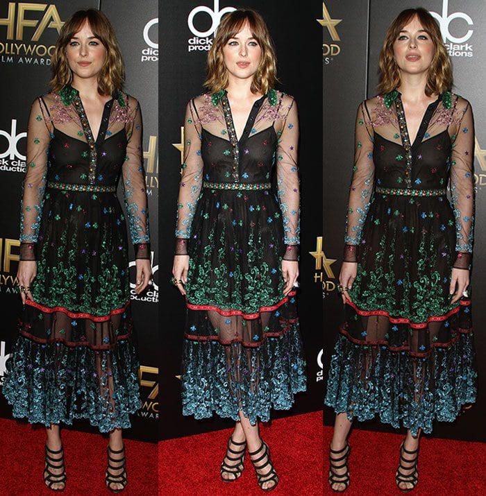 Dakota Johnson poses on the red carpet in a multi-colored embroidered dress from Gucci