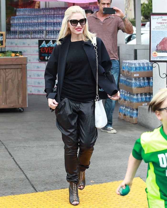 Gwen Stefani accessorizes with oversized sunglasses and a white shoulder bag