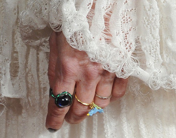 Julianne Moore adds a whimsical touch with statement cocktail rings and a polished manicure, perfectly complementing the delicate lace sleeves of her Alexander McQueen dress
