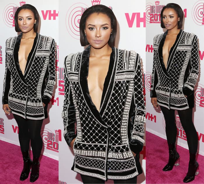 Kat Graham wore an exquisite blazer that showcased her ample assets with its daring plunging neckline, adorned with pearls for a touch of opulence