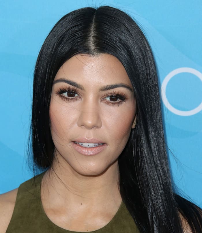 Kourtney Kardashian exudes effortless sophistication with sleek, straight hair and a neutral makeup palette that highlights her flawless complexion