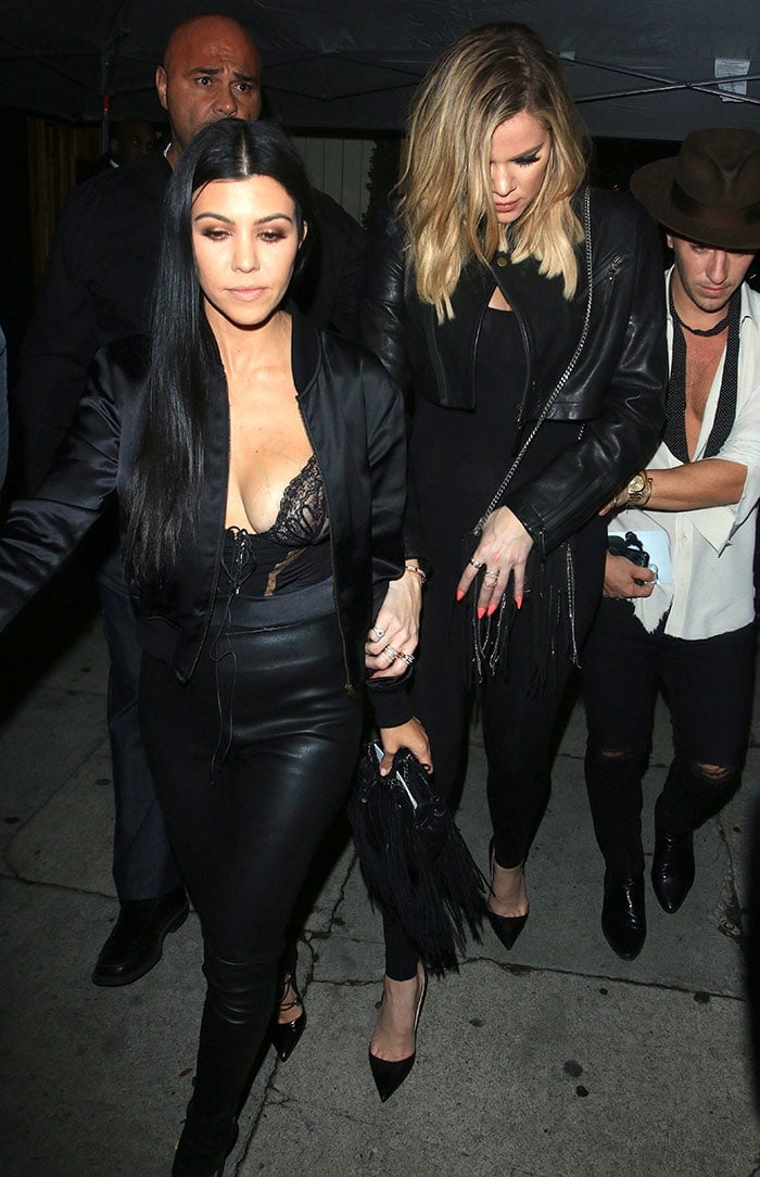 Kourtney Kardashian wears a sexy lingerie-style top and Balenciaga leather leggings as she arrives at Kendall Jenner's birthday party