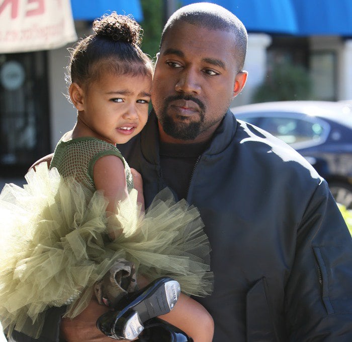 Kanye West carrying his daughter North West