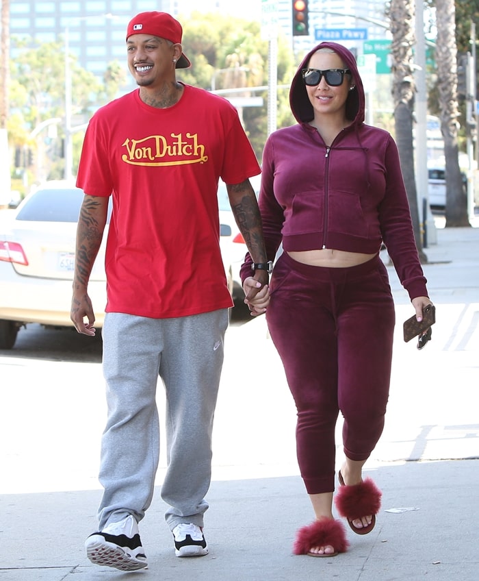 Pregnant Amber Rose wears a cropped velvet hoodie as she holds hands with her boyfriend Alexander Edwards