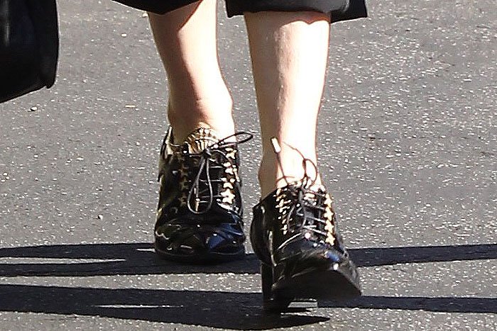Rose McGowan's black patent heeled oxfords with gold star eyelets