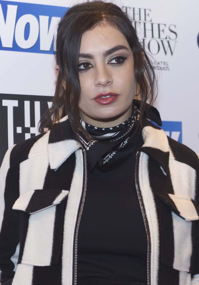 Charli XCX showing off her unique style in a striped jacket