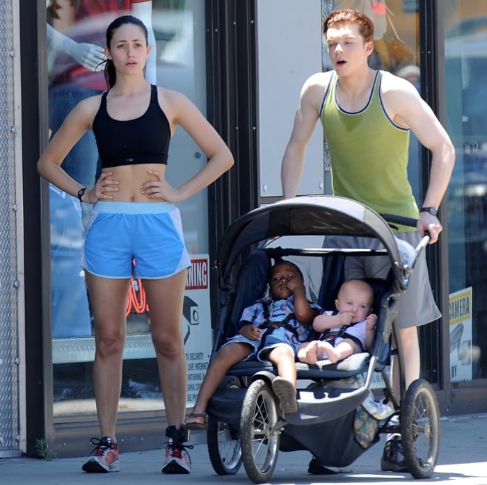 Emmy Rossum, in a black sports bra, light blue running shorts, and colorful trainers, films a workout scene with Cameron Monaghan for Shameless in Los Angeles on July 11, 2014